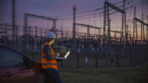 Electricity Maintenance Engineer working on the field at Power station at dusk.