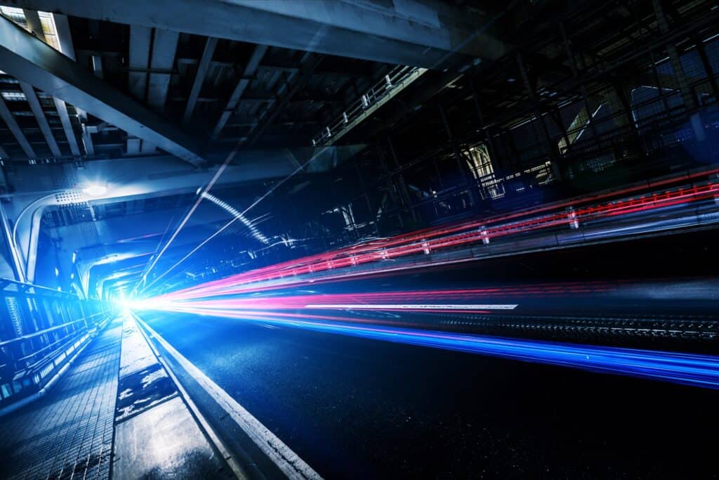 Tail light trails from driving on a bridge at night.