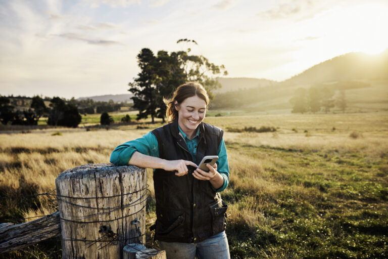 Young female farmer staying in touch via mobile technology from her farm in rural Tasmania, Australia.