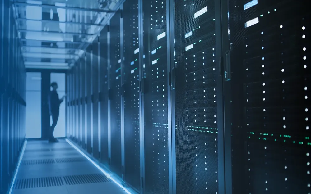 Technician looks at a row of servers - base station hotel.