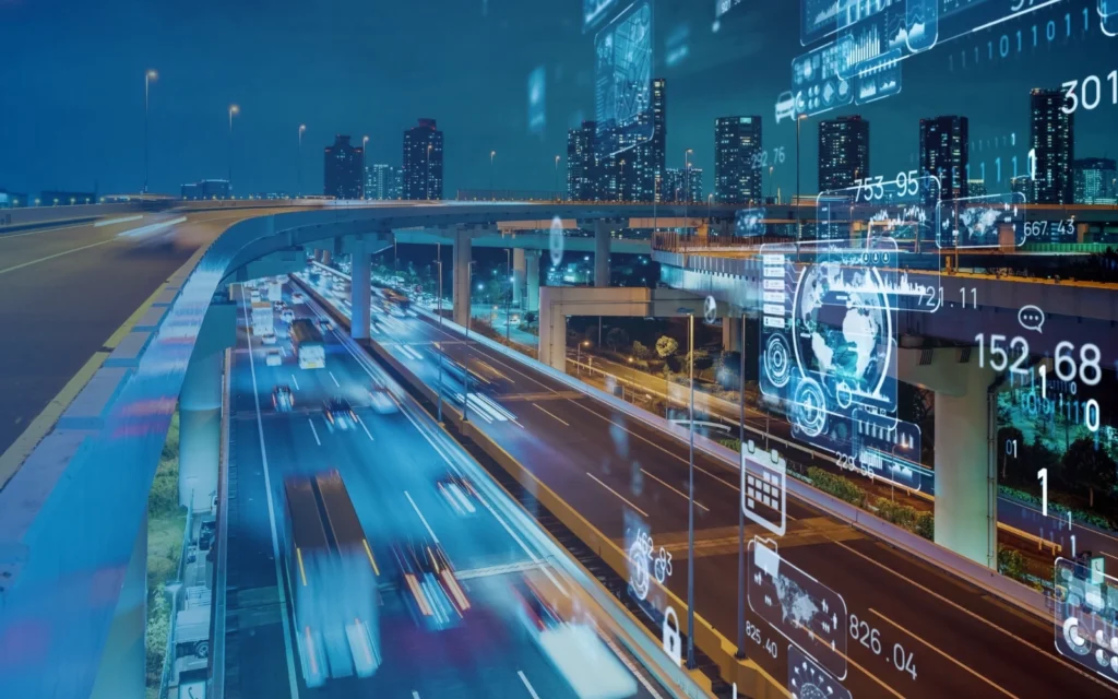 An elevated freeway at night with skyscrapers in the background and floating digital icons.