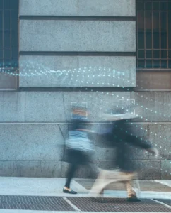 Blurred people against a stone buidling with boxes and dots overlayed.