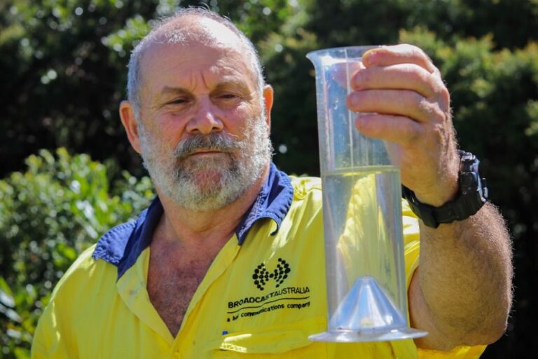 Broadcast Australia staff member checks water gauge.