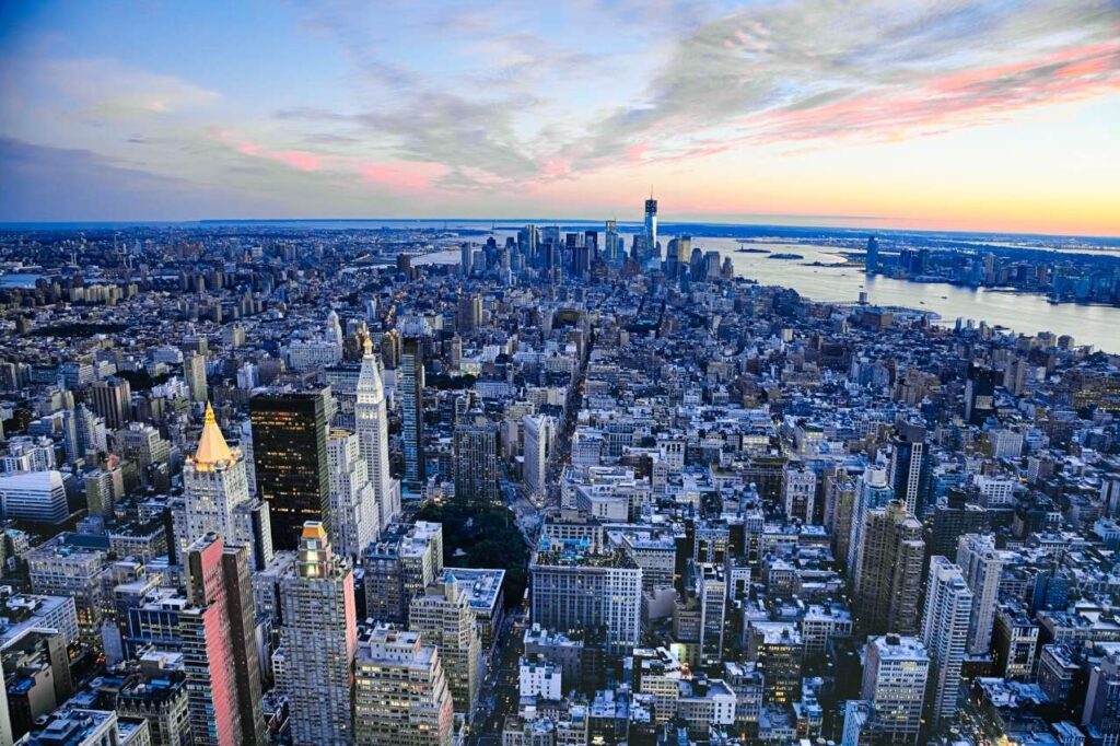 Aerial view of New York City at sunrise looking out towards the ocean.