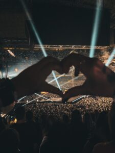 Looking through hands making a heart shape at a concert.